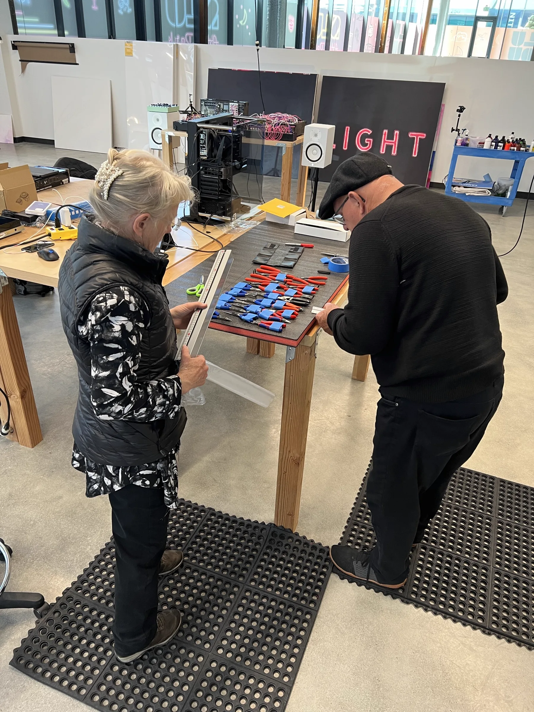 Joshua Borsman's parents working together on a foam-cut tool organizer at the studio workbench